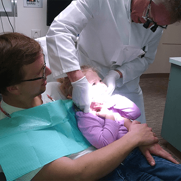Dr. with Kid's Teeth Treatment - Dentist Near Me